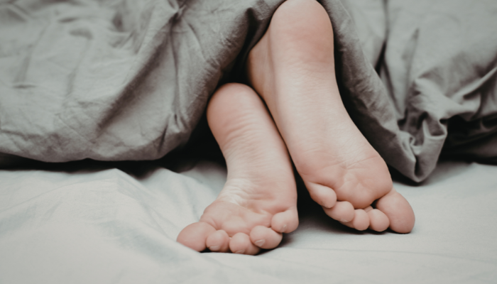Por que algumas pessoas dormem com uma perna para fora da coberta? A ciência e os motivos por trás desse hábito